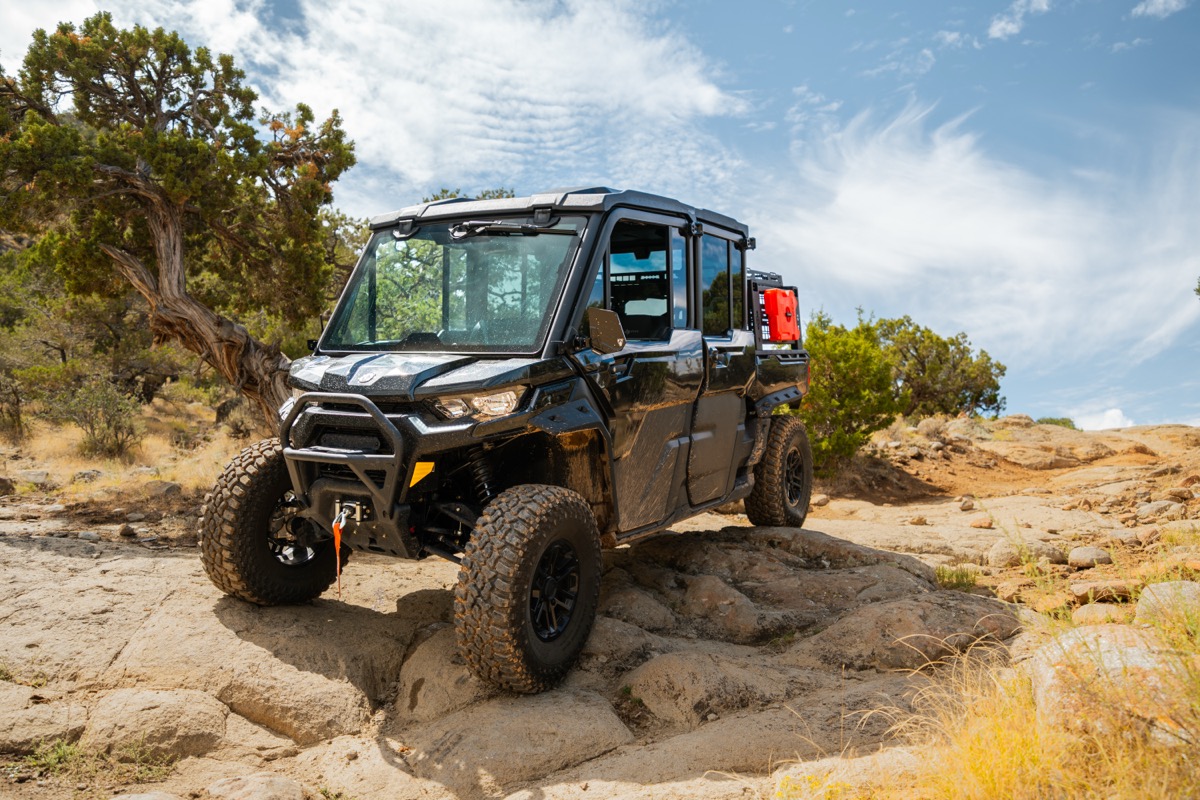 Can-Am Defender MAX crew cab navigating rocky terrain in Southern Utah with full cab enclosure and work accessories