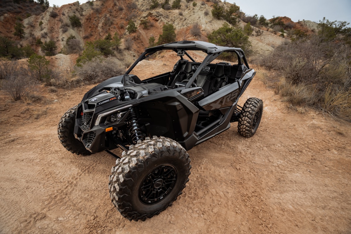 Can-Am Maverick X3 parked on a Southern Utah canyon trail with red rock terrain and desert brush in the background