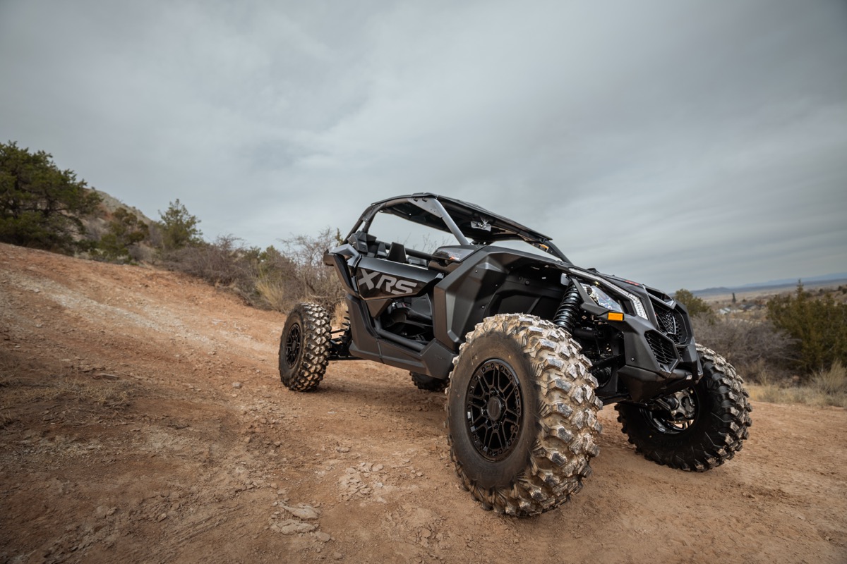 Can-Am Maverick X3 XRS front suspension and chassis detail on a Southern Utah dirt trail showing Fox shocks and A-arm geometry