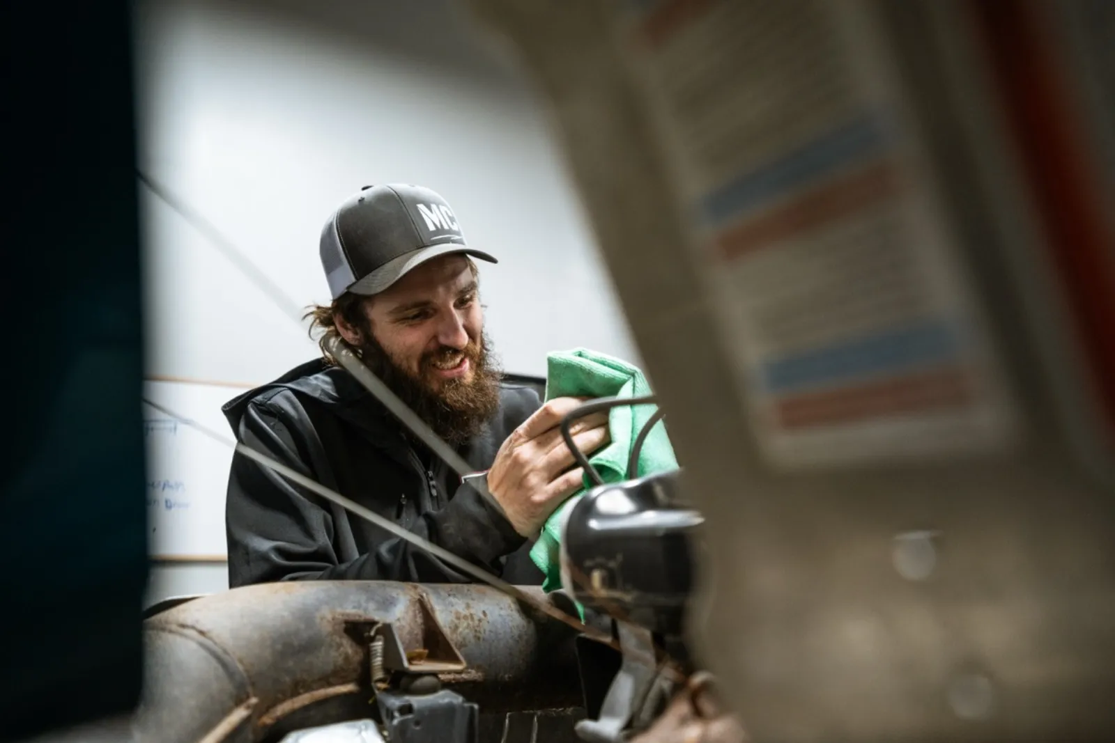 D&P Performance technician smiling while working on powersports machine in Cedar City shop