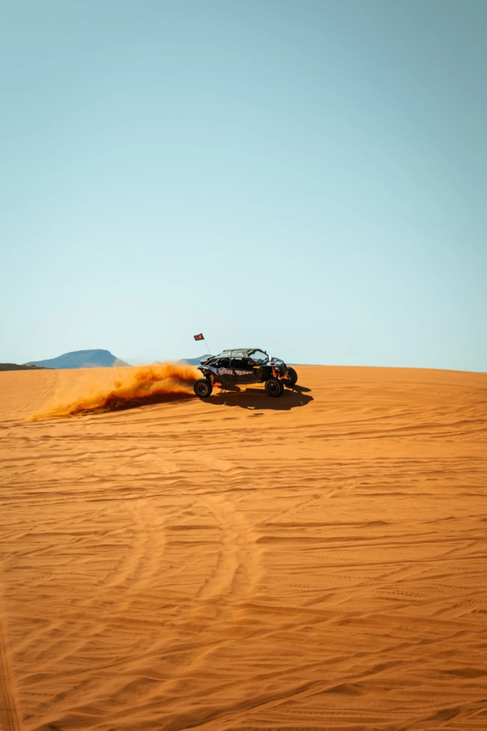 UTV kicking up dust while riding sand dunes in Southern Utah near Cedar City